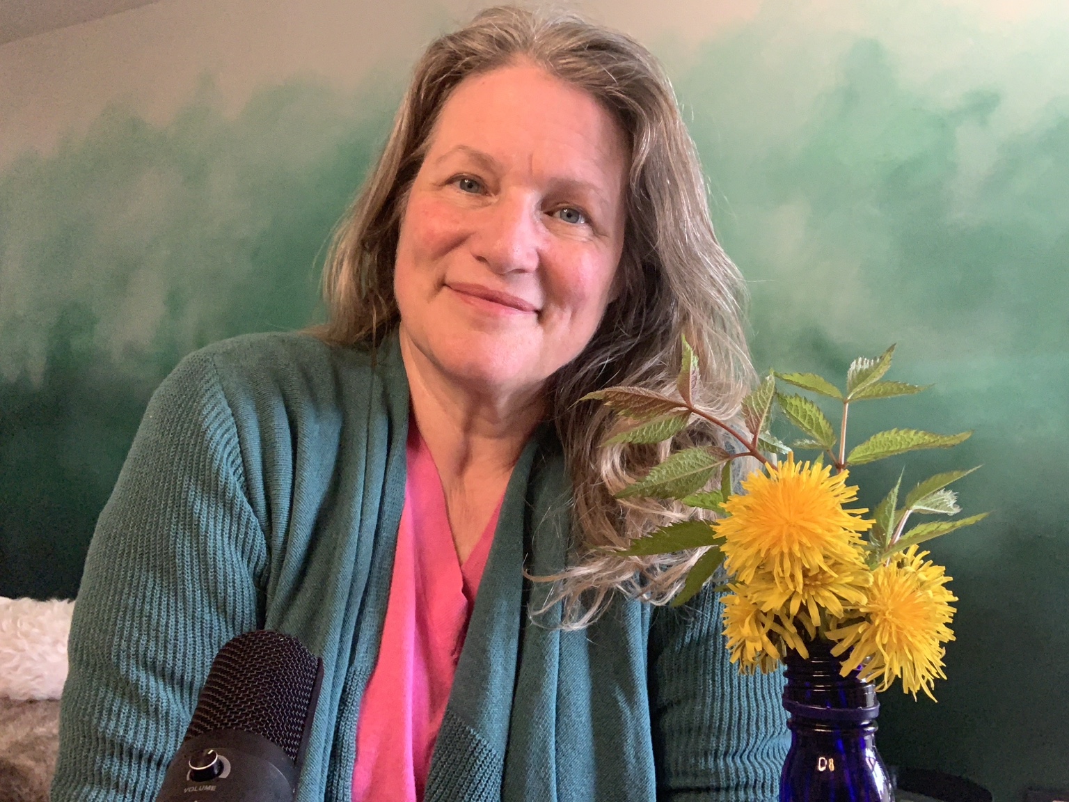 Terra Lea smiling beside a vase of bright yellow flowers